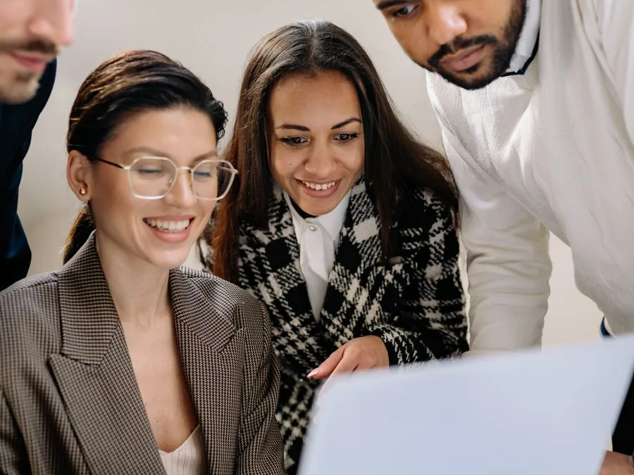 Project team reviewing work together on a laptop
